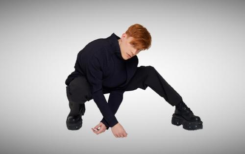 Loïc Nottet porte un top homme plissé Issey Miyake et un pantalon oversized ZARA.